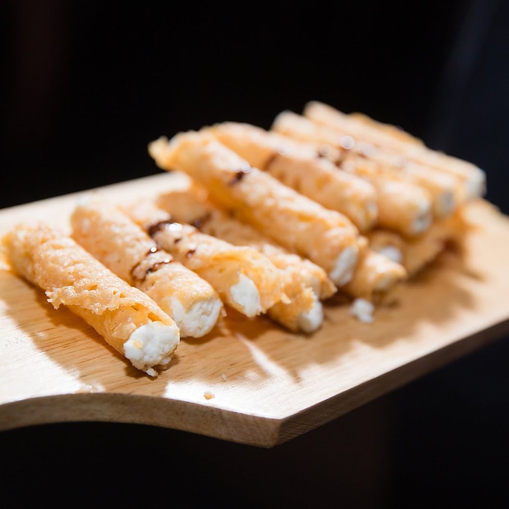 Passed crispy cheese sticks on a wood board
