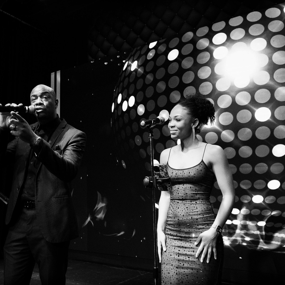 Singers performing beneath a wall of spinning lights