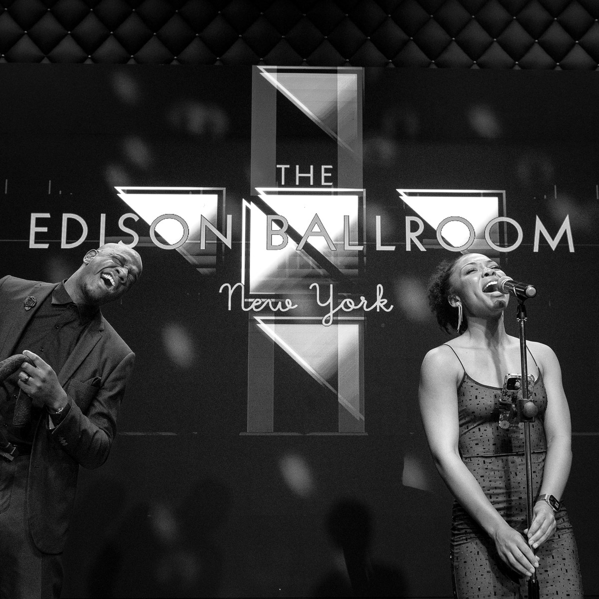 Singers performing in front of the Edison Ballroom logo on the LED wall
