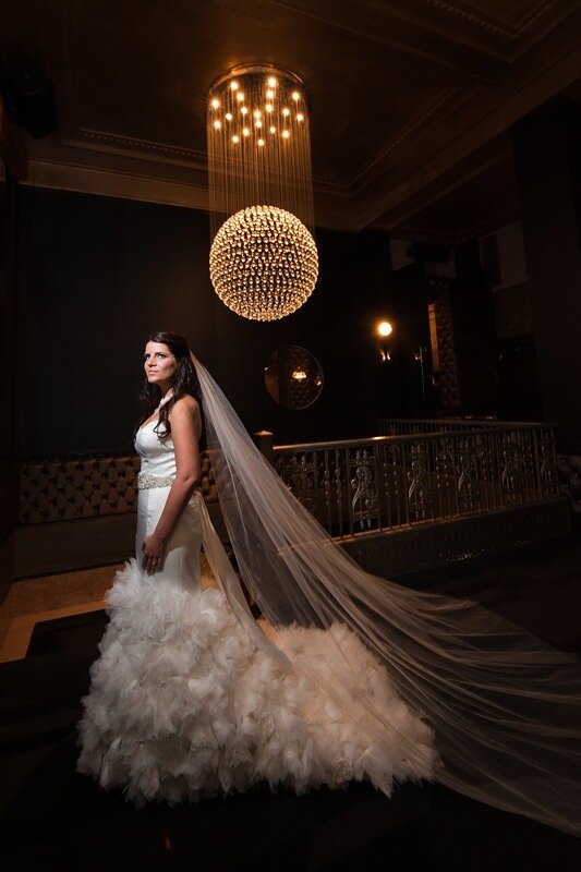 Bride beneath the Edison Ballroom's gold crystal chandelier
